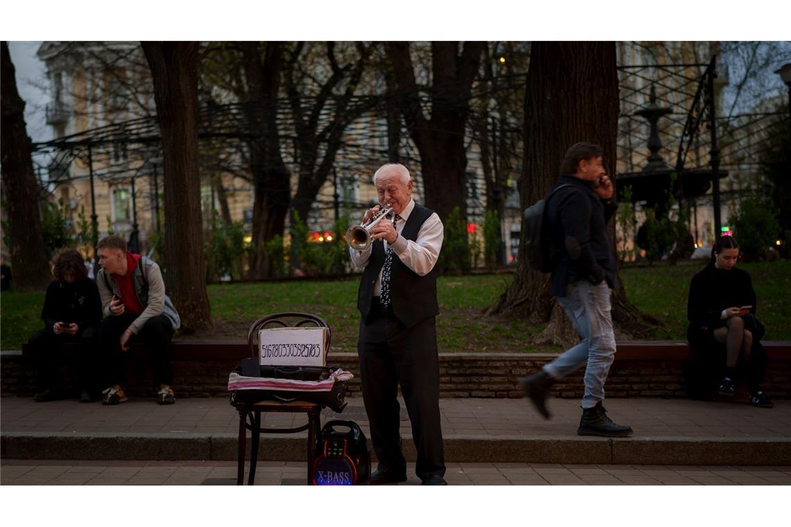 Ein Mann spielt Trompete in einem Park in Kiew, Ukraine.