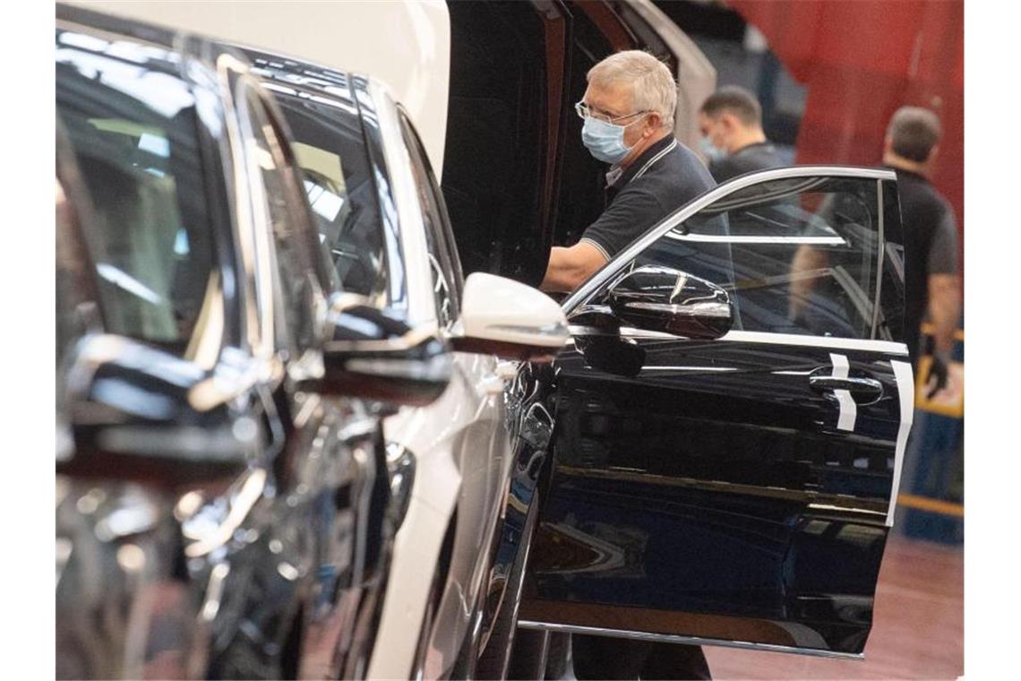 Ein Mitarbeiter der Daimler AG hat in der Produktion der S-Klasse einen Mundschutz an. Foto: Marijan Murat/dpa