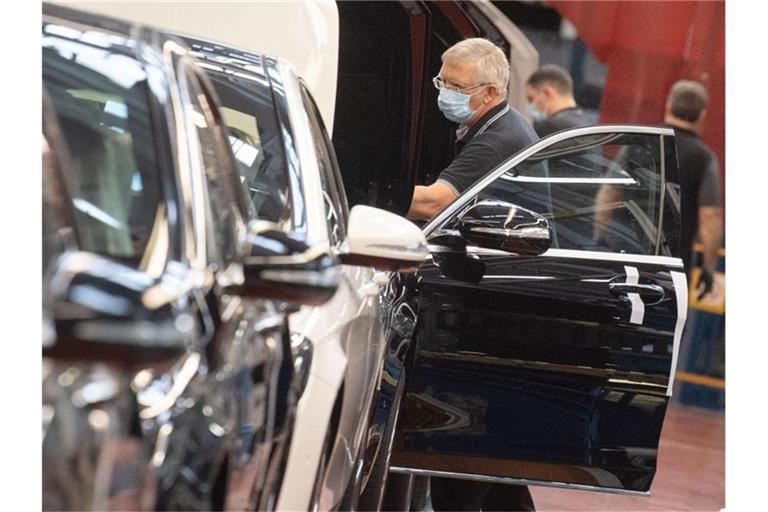 Ein Mitarbeiter der Daimler AG hat in der Produktion der S-Klasse einen Mundschutz an. Foto: Marijan Murat/dpa