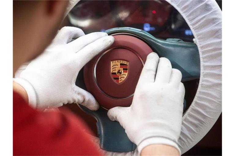 Ein Mitarbeiter der Porsche AG montiert im Hauptwerk ein Airbagmodul. Foto: Marijan Murat/dpa