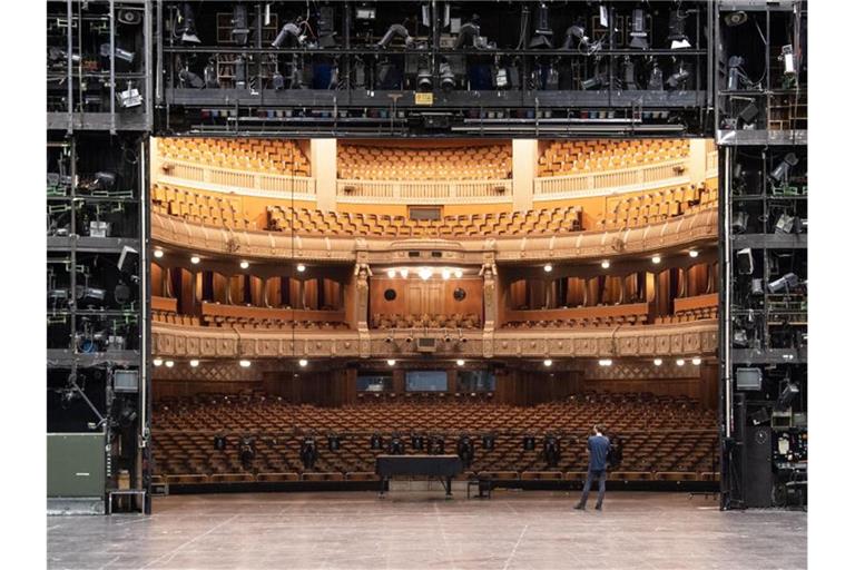 Ein Mitarbeiter der Staatstheater Stuttgart steht auf der Bühne des Opernhauses. Foto: Marijan Murat/dpa/Archivbild