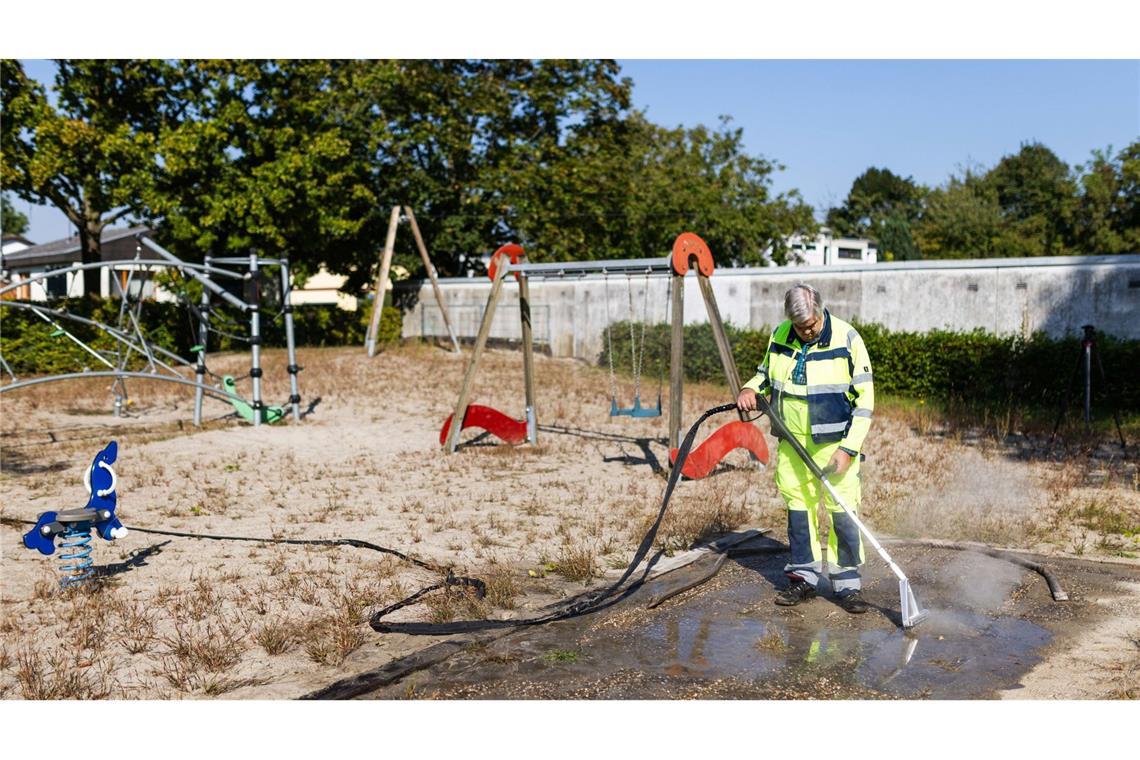 Ein Mitarbeiter der Stadt Kehl spritzt heißes Wasser in die Eingänge eines riesigen Ameisenbaus, der sich unter einem Spielplatz erstreckt.