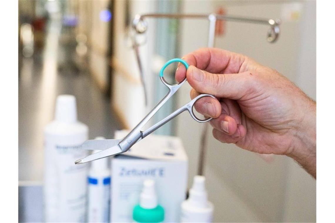 Einweg in Kliniken: Tausende Tonnen Edelstahl landen im Müll Ein Mitarbeiter hält in einer Klinik eine Schere aus nicht-wiederverwendbarem Edelstahl. Foto: Philipp von Ditfurth/dpa/Archivbild