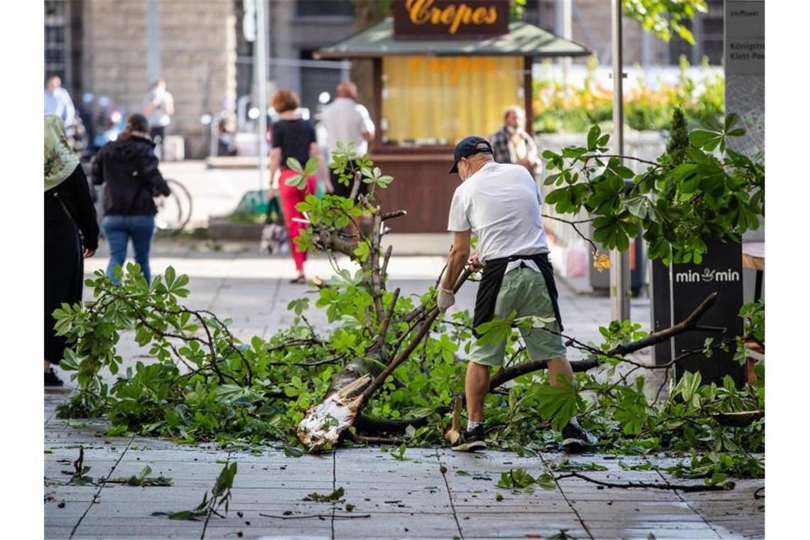 Ein Mitarbeiter räumt den Außenbereich eines Restaurants in Stuttgart frei. Foto: Christoph Schmidt/dpa