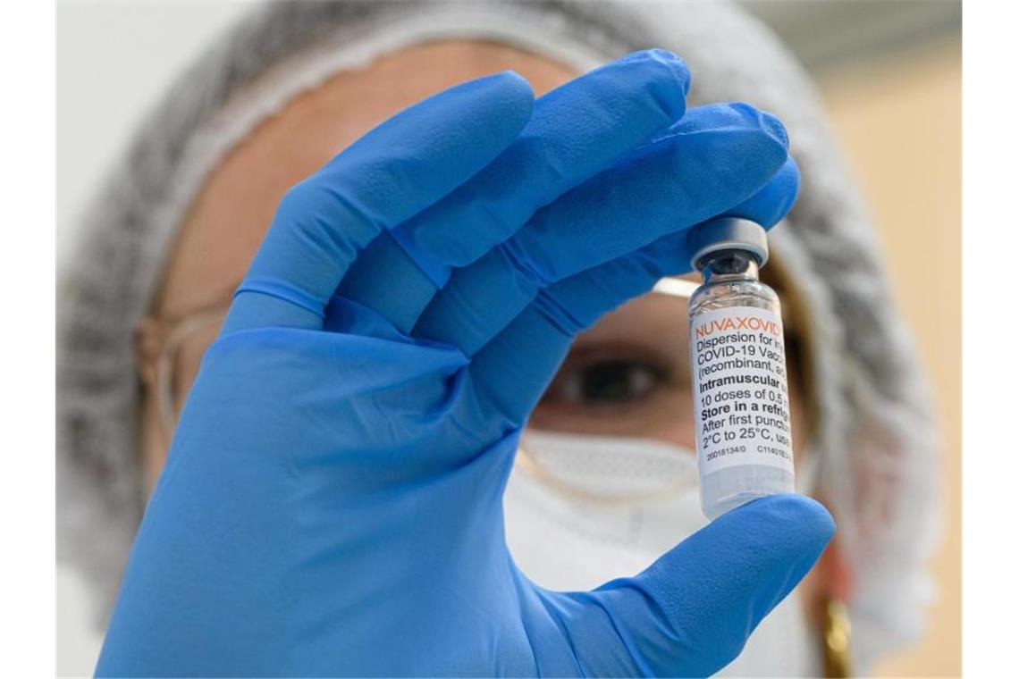 Bundesländer setzen Teil-Impfpflicht unterschiedlich um Ein Mitarbeiterin im Impfzentrum hält eine Ampulle mit dem neuen Corona-Impfstoff von Novavax in der Hand. Foto: Robert Michael/dpa-Zentralbild/dpa