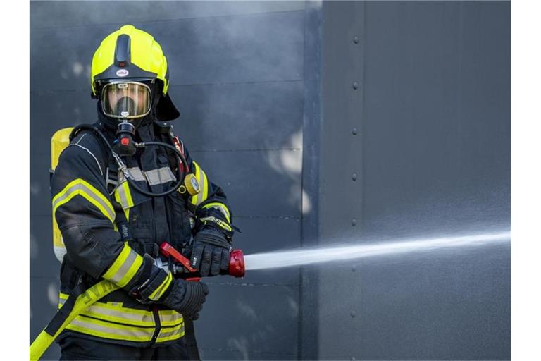 Ein Mitglied der Feuerwehr im Löscheinsatz. Foto: David Inderlied/dpa/Symbolbild