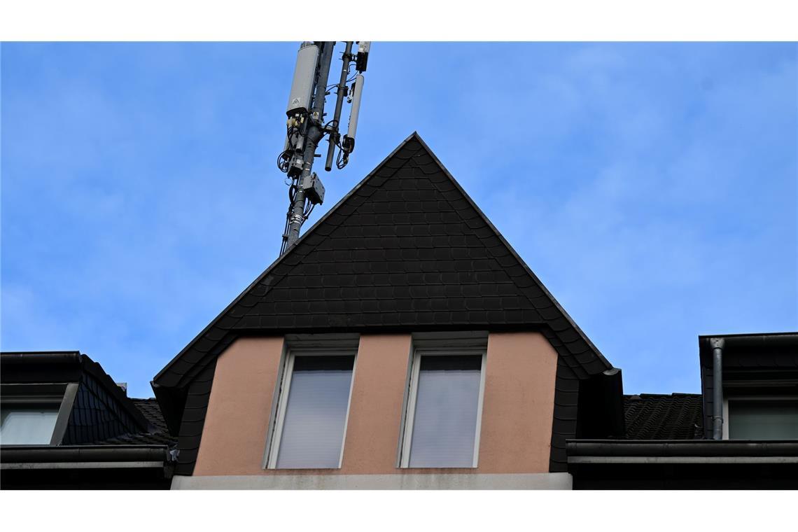 Ein Mobilfunk-Mast mit Antennen im Funkstandard 5G (quadratisch) und 4G (länglich) ist auf dem Dach eines Wohnhauses montiert. (Archivbild)