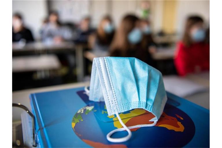 Ein Mund- und Nasenschutz liegt im Unterricht einer Schulkasse. Foto: Matthias Balk/dpa/Symbolbild