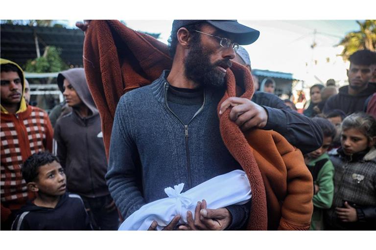 Ein muslimischer Geistlicher legt eine Decke um den Vater des neugeborenen Jumaa al-Batran, der Berichten zufolge an Unterkühlung gestorben ist.