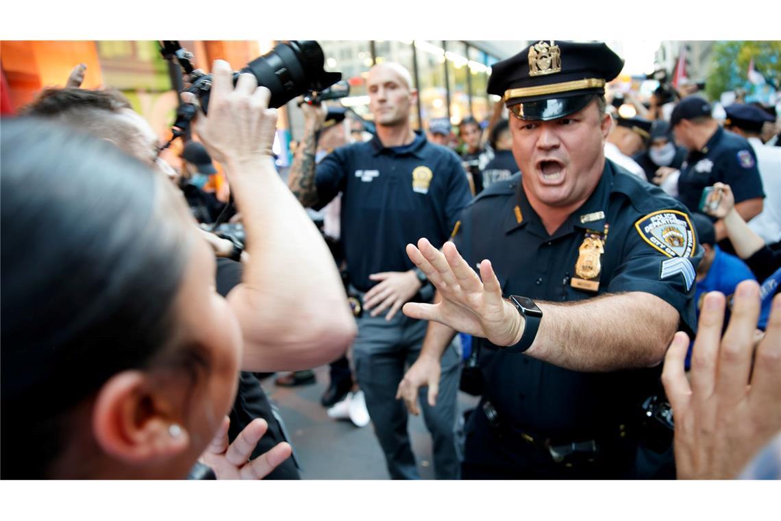 Ein New Yorker Polizist versucht Demonstranten während einer pro-palästinensischen Demonstration aufzuhalten.