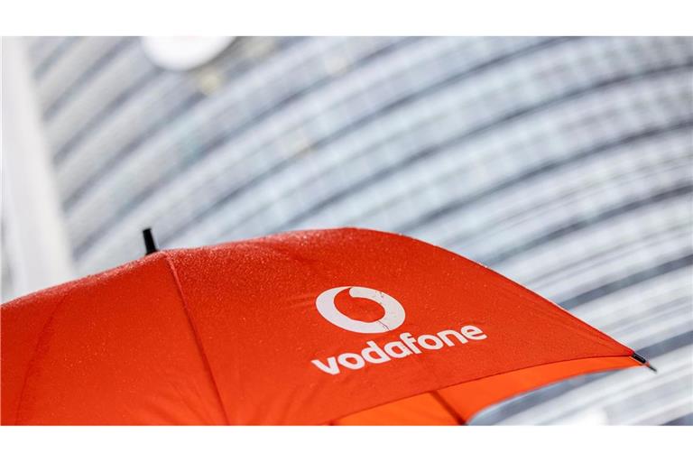 Ein Passant geht mit einem aufgespanntem Regenschirm mit dem Logo von Vodafone an der Zentrale der Deutschlandtochter des britischen Vodafone-Konzerns vorbei.