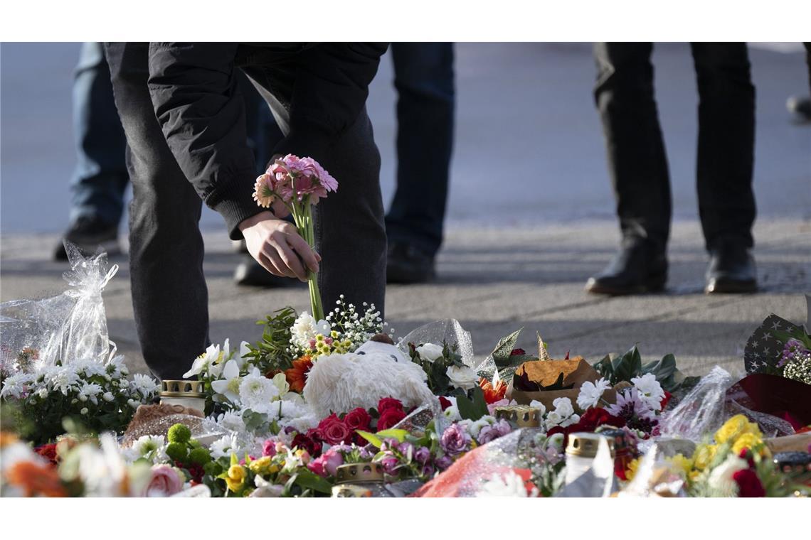 Ein Passant legt Blumen vor dem Eingang der Johanniskirche an einer Andachtsstätte in Magdeburg nieder. (Archivbild)