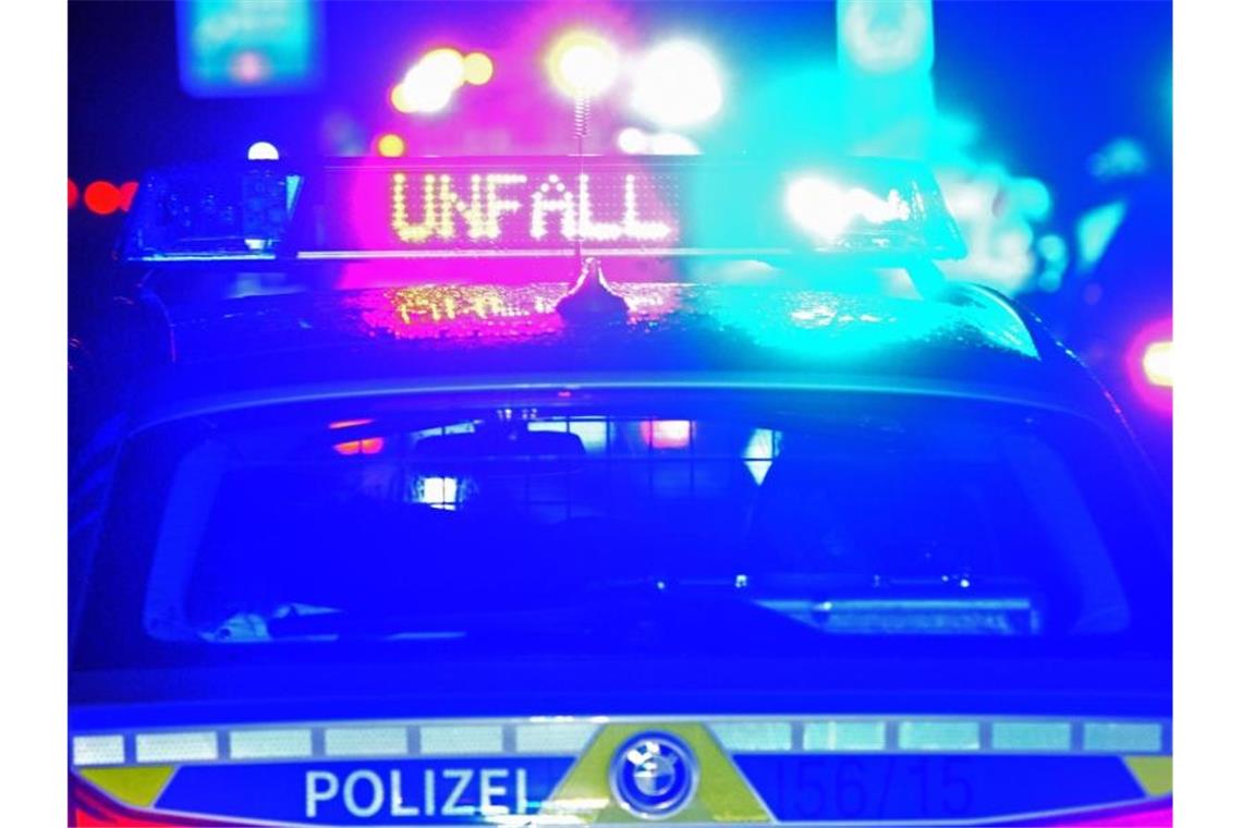 Trümmerfeld nach Sekundenschlaf auf Autobahn Ein Polizeiauto warnt vor einer Unfallstelle. Foto: Stefan Puchner/dpa/Archivbild