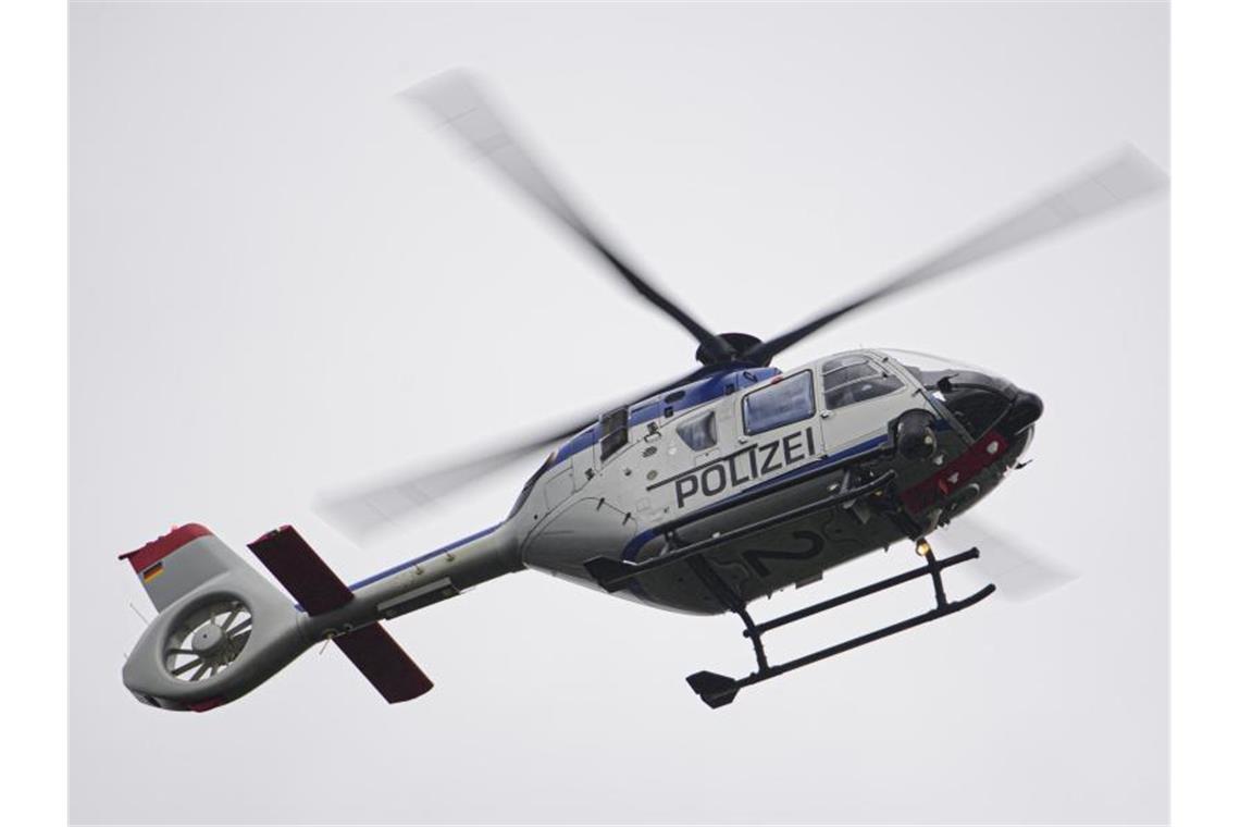 Mann überschlägt sich mit Auto und flüchtet vor der Polizei Ein Polizeihubschrauber fliegt bei einem Sucheinsatz über eine Stadt. Foto: Robert Michael/dpa-Zentralbild/ZB/Symbolbild