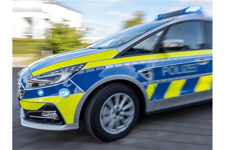 Ein Polizeiwagen fährt mit eingeschaltetem Blaulicht. Foto: David Inderlied/dpa/Illustration