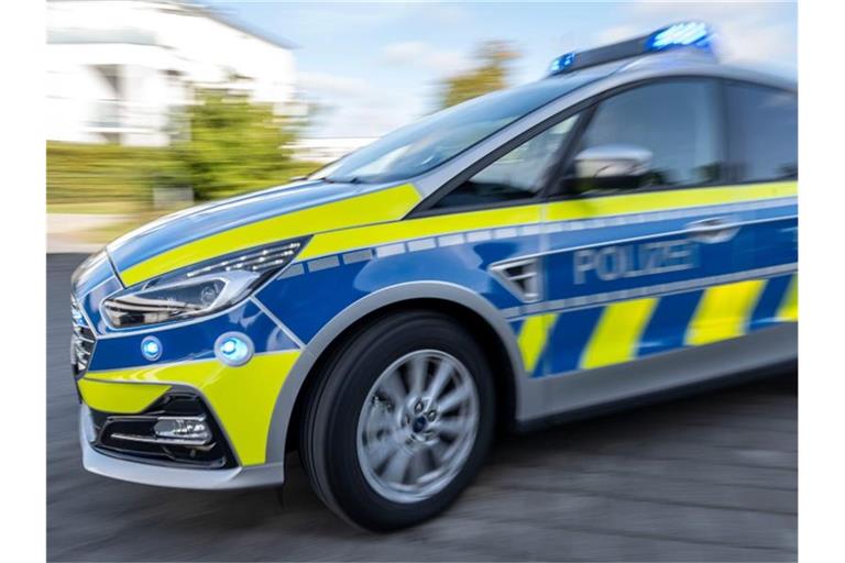 Ein Polizeiwagen fährt mit eingeschaltetem Blaulicht. Foto: David Inderlied/dpa/Illustration