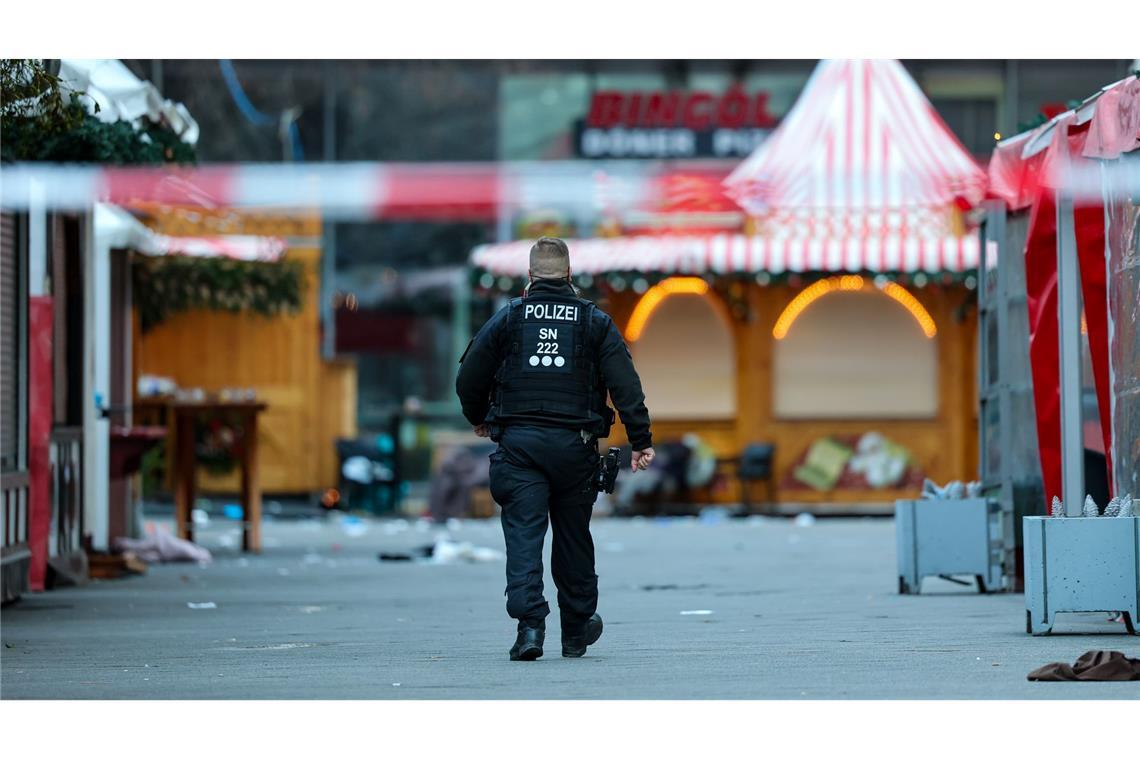 Ein Polizist geht hinter einer Absperrung am Magdeburger Weihnachtsmarkt.