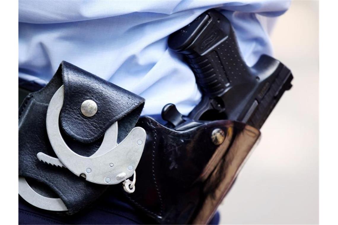 Frau durchwühlt Krankenwagen: Haftbefehl lag schon vor Ein Polizist mit Handschellen und Pistole am Gürtel. Foto: Oliver Berg/dpa