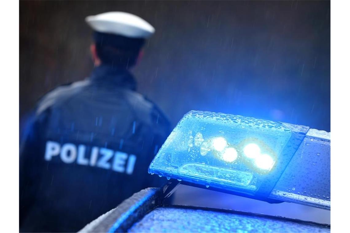 Razzia nach Schleuserverdacht wegen illegaler Beschäftigung Ein Polizist steht vor einem Streifenwagen. Foto: Karl-Josef Hildenbrand/dpa/Symbolbild