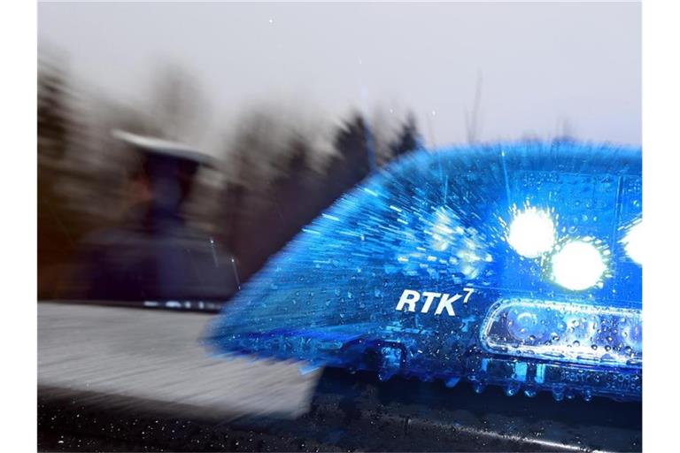 Ein Polizist steht vor einem Streifenwagen. Foto: Karl-Josef Hildenbrand/dpa/Illustration