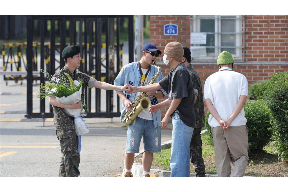 Ein Popstar-Status schützt in Südkorea nicht vorm Wehrdienst: Das Mitglied der K-Pop-Band BTS, Jin (l), wird aus dem Militärdienst entlassen.