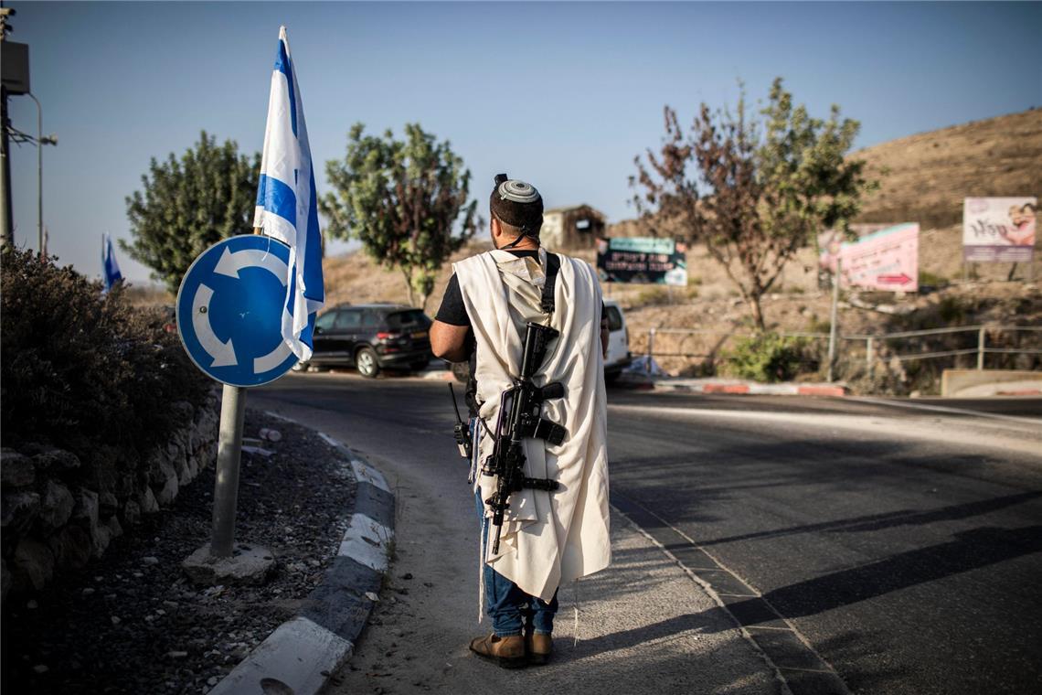 Ein rechtsgerichteter israelischer Siedler trägt eine Waffe am Haupteingang der palästinensischen Stadt Nablus (Archivfoto).