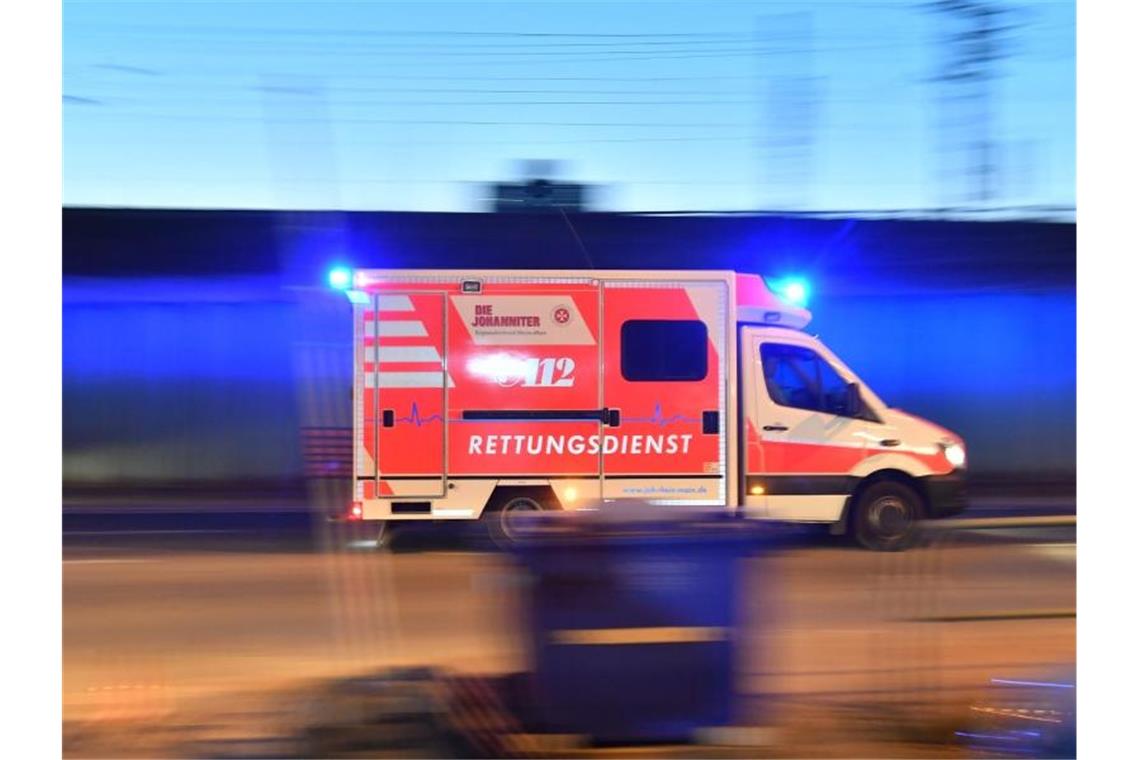 Frau wird von Auto erfasst und stirbt Ein Rettungswagen ist mit eingeschaltetem Blauchlicht im Einsatz. Foto: Boris Roessler/dpa/Archivbild