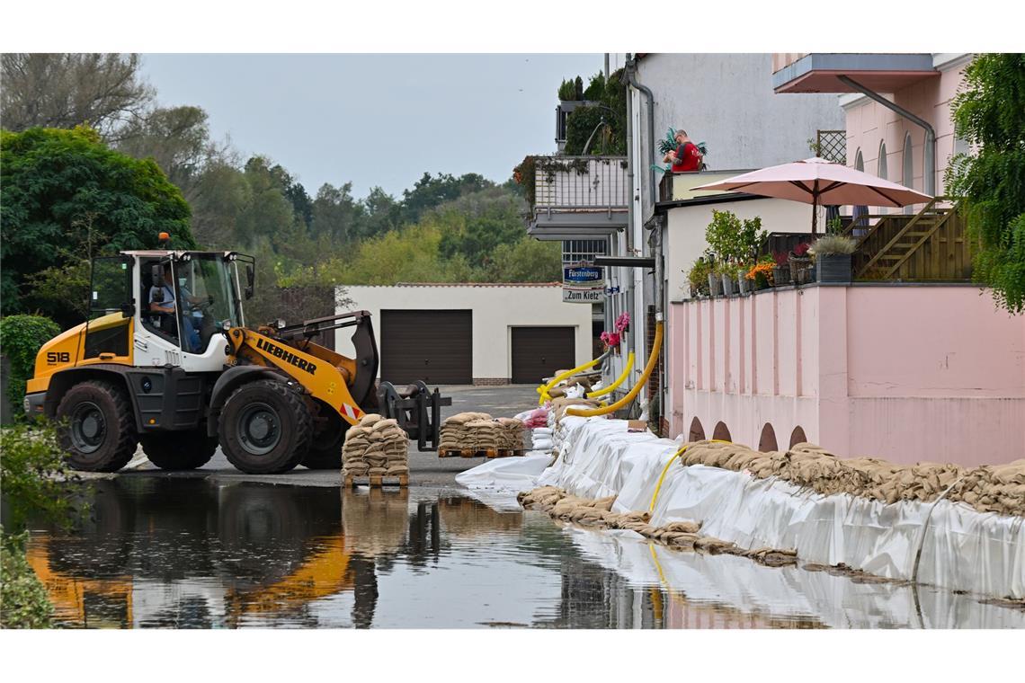 Ein Sandsack-Wall wird in einem Stadtteil von Eisenhüttenstadt verstärkt. Dort hat das Hochwasser Straßen überflutet.