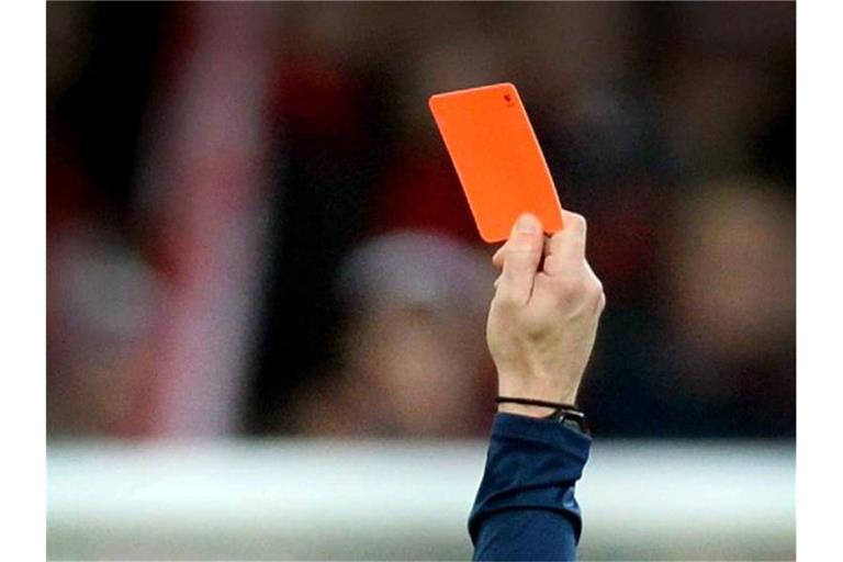 Ein Schiedsrichter zeigt einem Fußballspieler die rote Karte. Foto: Patrick Seeger/Archiv