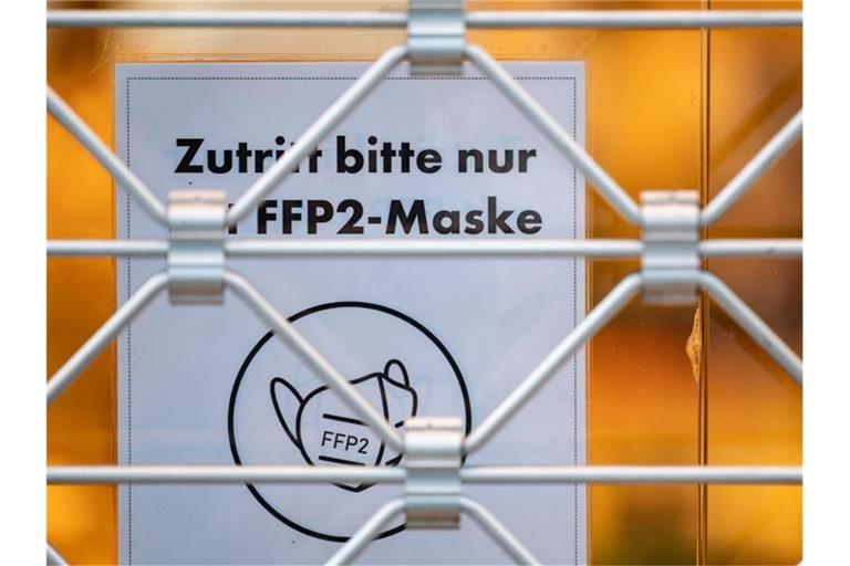 Ein Schild auf der Tür eines Einzelhandelsgeschäfts weist auf das Tragen einer FFP2-Maske hin. Foto: Marijan Murat/dpa