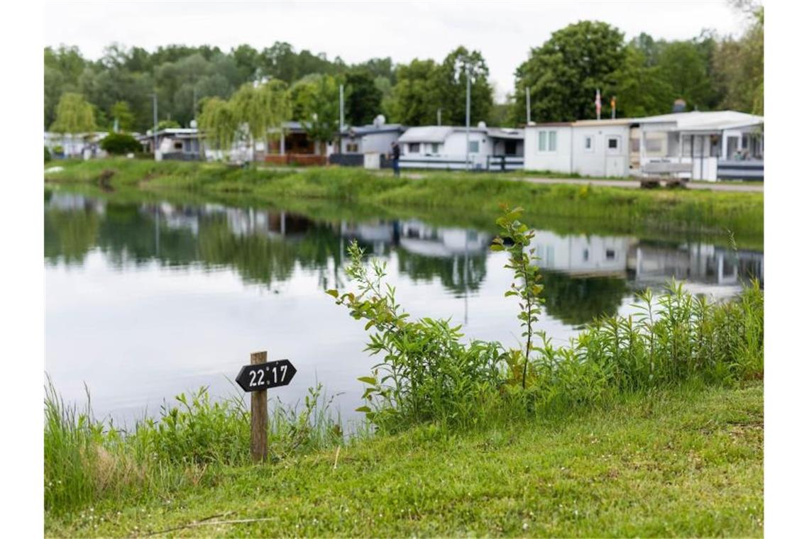 Ab in den Urlaub: mit Test, Impfpass oder Genesenen-Nachweis Ein Schild auf einem Campingplatz weist Stellplätze aus, im Hintergrund stehen Wohnwägen von Dauercampern. Foto: Philipp von Ditfurth/dpa/Archivbild