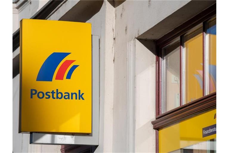 Ein Schild mit dem Logo der Postbank ist an der Fassade einer Bankfiliale angebracht. Foto: Monika Skolimowska/dpa-Zentralbild/dpa/Archiv