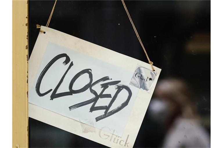 Ein Schild mit der englischen Aufschrift „Closed“ hängt an der Tür. Foto: Uwe Anspach/dpa/Archivbild