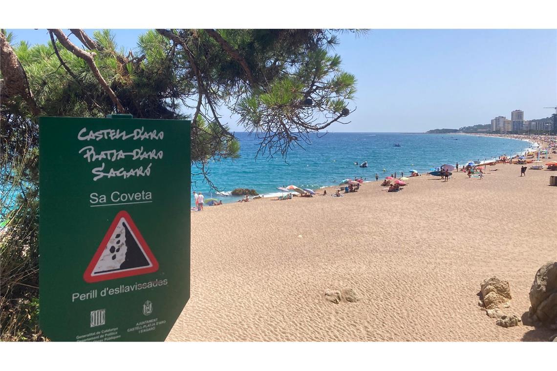 Ein Schild weist an der Platja Gran, dem "Großen Strand", auf Steinschlag hin.