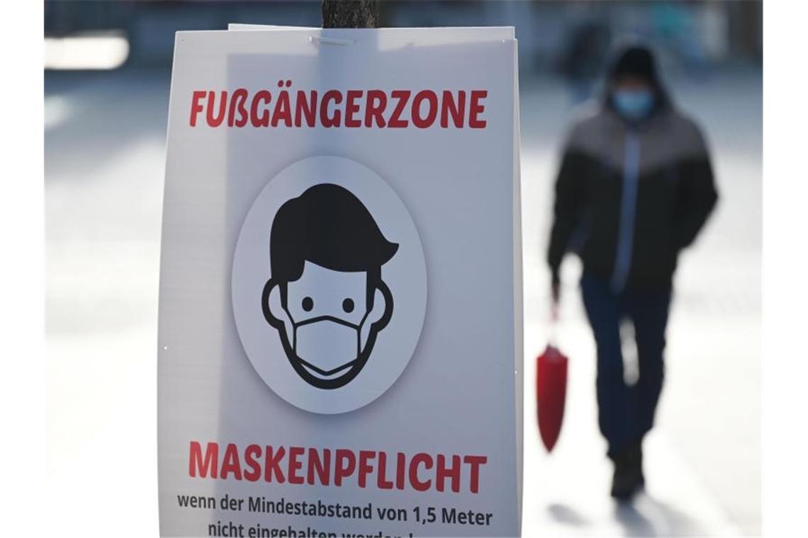 Regierung fordert Umsetzung der Corona-Notbremse Ein Schild weist auf die Maskenpflicht in der Fußgängerzone von Göppingen hin. Foto: Marijan Murat/dpa