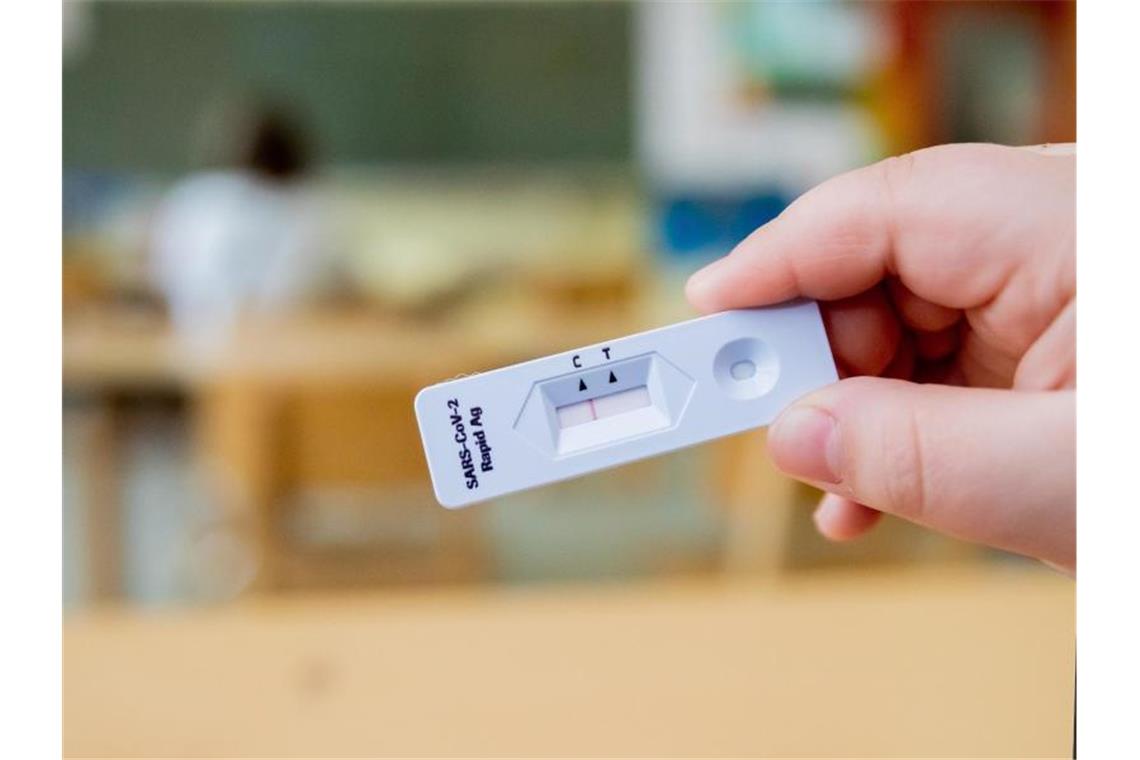 Ein Schüler hält einen negativen Corona-Schnelltest in der Hand. Foto: Christoph Soeder/dpa/Symbolbild