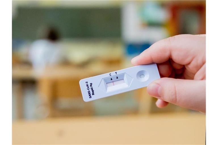 Ein Schüler hält einen negativen Corona-Schnelltest in der Hand. Foto: Christoph Soeder/dpa/Symbolbild