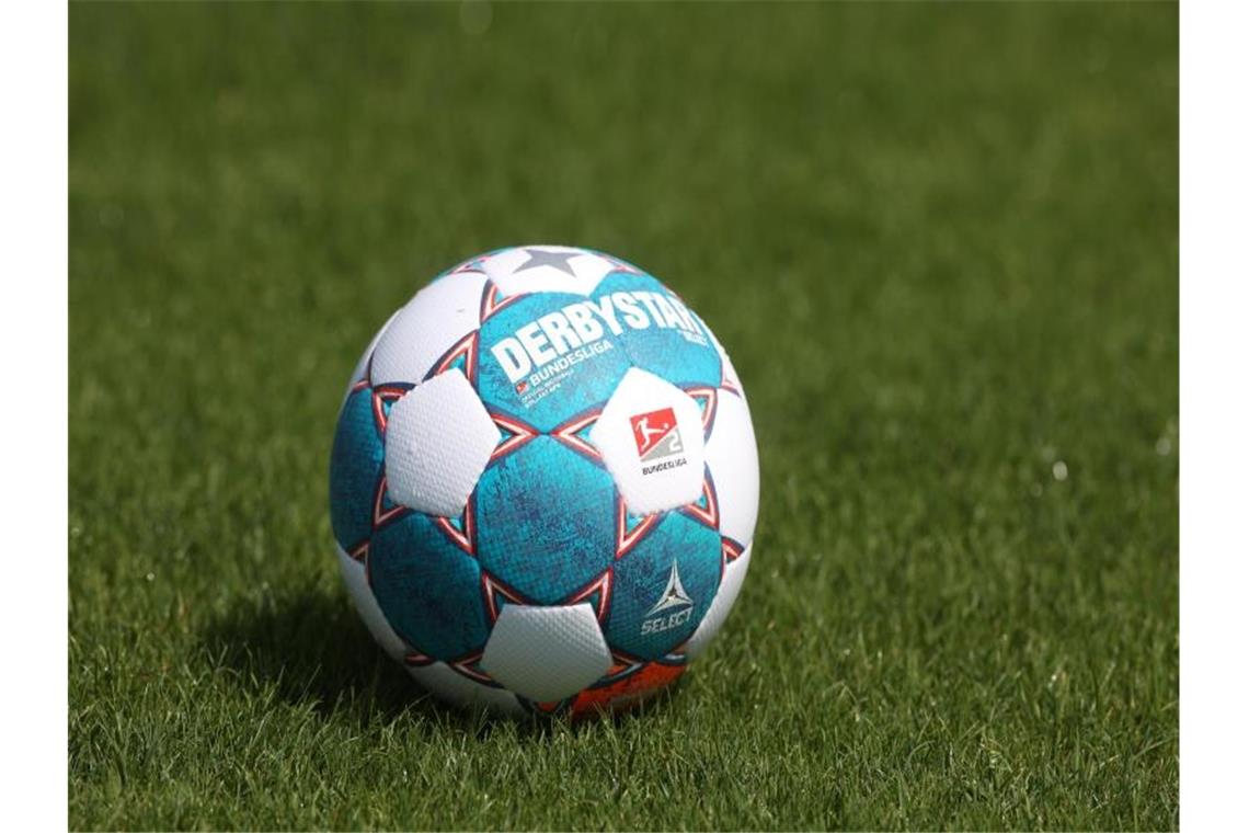 Ein Spielball liegt auf dem Rasen. Foto: Guido Kirchner/dpa/Symbolbild