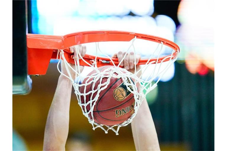 Ein Spieler wirft einen Basketball in den Korb. Foto: Uwe Anspach/dpa/Archivbild/Symbolbild