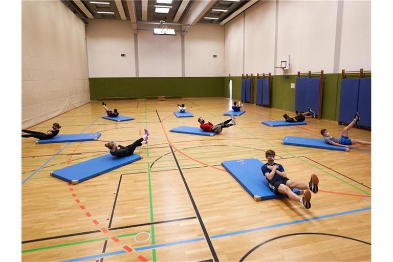 Ein Sportlehrer zeigt seinen Schülern Übungen. Foto: Thomas Frey/dpa/Symbolbild