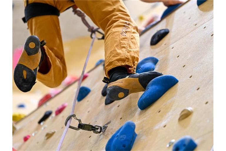 Ein Sportler klettert in einer Kletterhalle die Wand hinauf. Foto: Felix Kästle/dpa