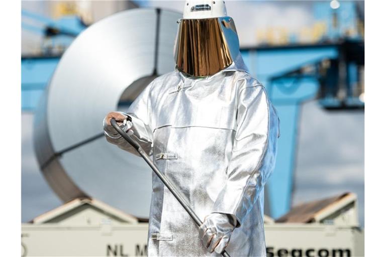 Ein Stahlarbeiter steht auf dem Gelände von ThyssenKrupp vor einer Stahlblechrolle. Foto: Jonas Güttler/dpa