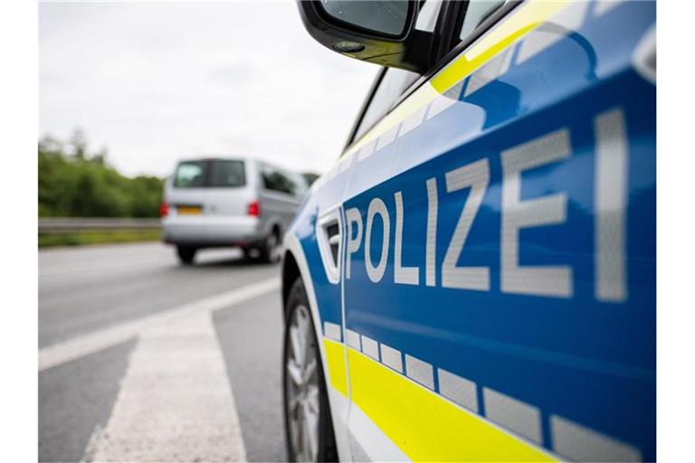 Ein Streifenwagen der Polizei steht auf einer Straße. Foto: Guido Kirchner/dpa/Symbolbild