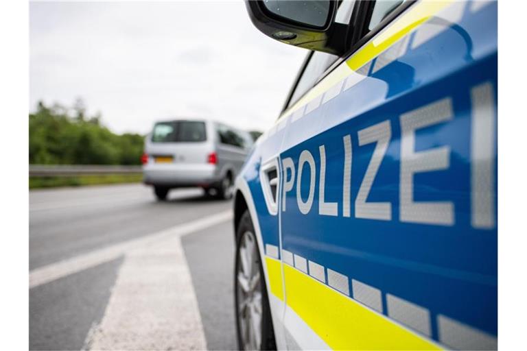 Ein Streifenwagen der Polizei steht auf einer Straße. Foto: Guido Kirchner/dpa/Symbolbild