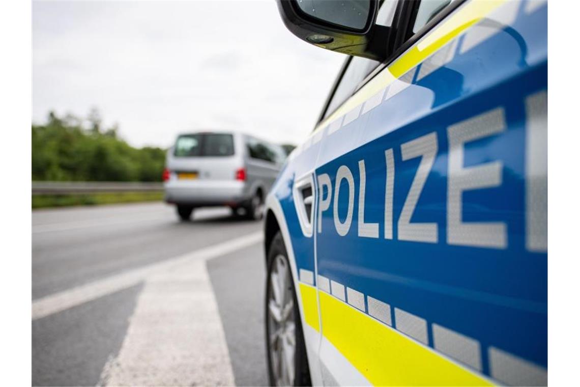 Ein Streifenwagen der Polizei steht auf einer Straße. Foto: Guido Kirchner/dpa/Symbolbild