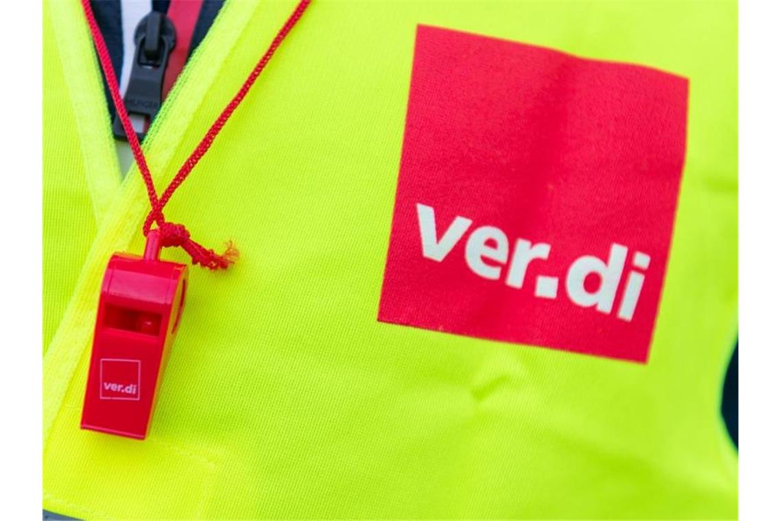 Ein Streikender mit einer Warnweste mit dem Verdi-Logo und einer roten Trillerpfeife. Foto: Christophe Gateau/dpa/Symbolbild