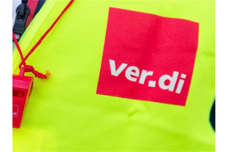 Ein Streikender trägt eine Warnweste mit dem Verdi-Logo und eine rote Trillerpfeife. Foto: Christophe Gateau/dpa/Symbolbild