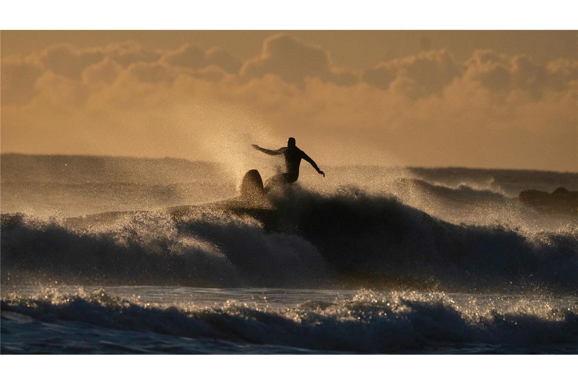 Ein Surfer ist an der englischen Nordseeküste auf der Jagd nach der perfekten Welle.