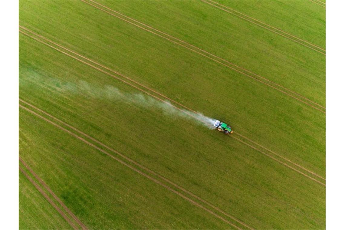 Minister beraten über Agrarpolitik Ein Traktor fährt bei Gammelin über einen Acker und verteilt mit einem Streuer Pflanzendünger. Foto: Jens Büttner/dpa-Zentralbild/dpa