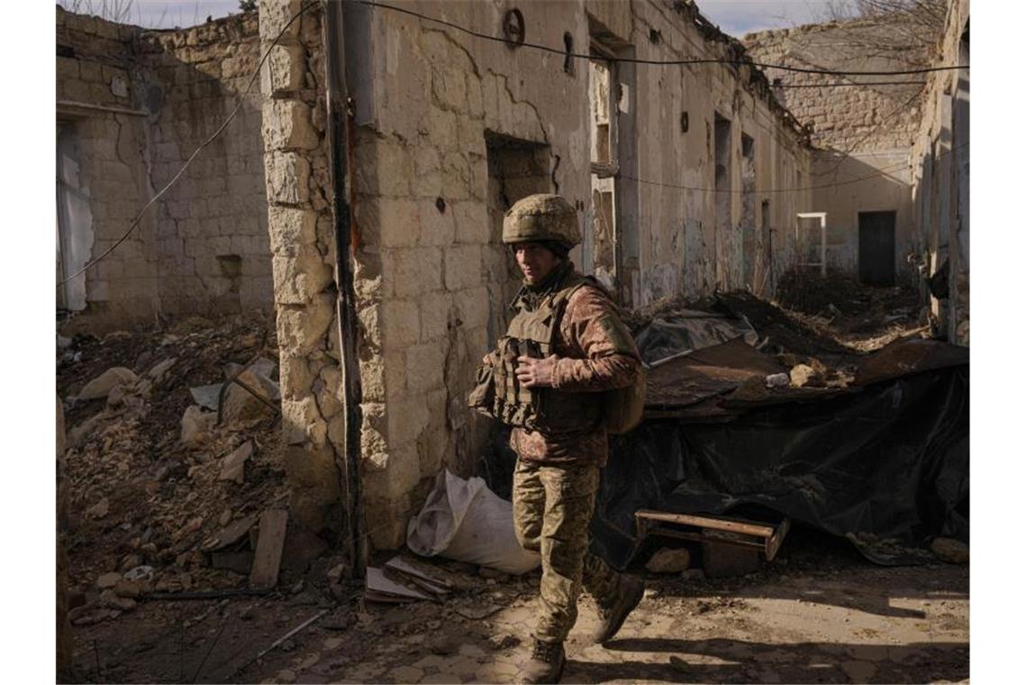 Nato befürchtet „vollständigen Angriff“ auf Ukraine Ein ukrainischer Soldat geht in einem zerstörten Haus in der Nähe des Grenzdorfes Krymske in der Region Luhansk im Osten der Ukraine spazieren. Foto: Vadim Ghirda/AP/dpa